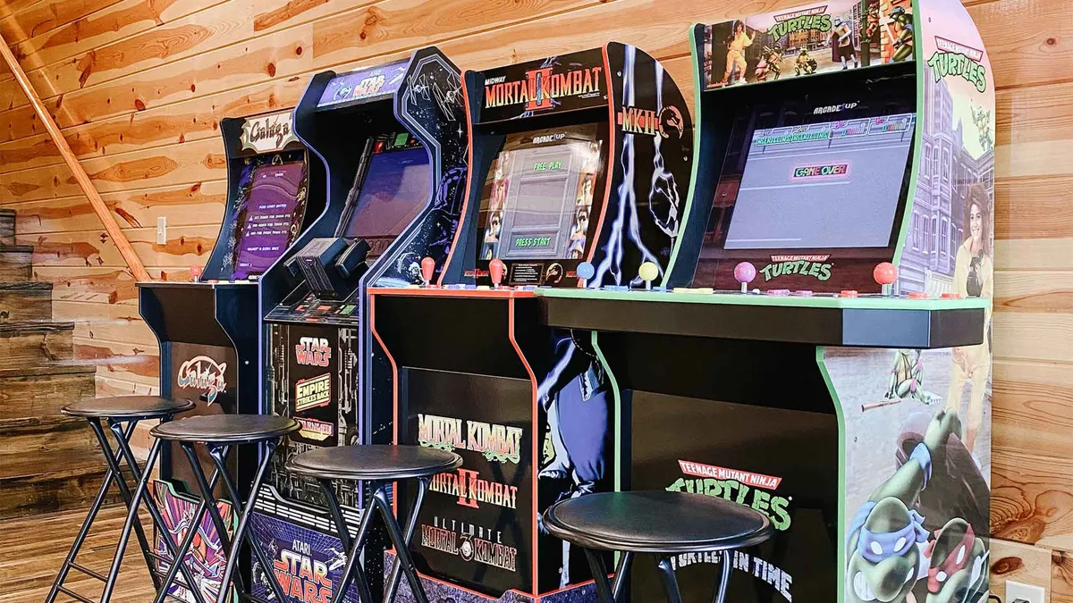 A vibrant game room featuring arcade machines, bar stools, and rustic wooden wall textures. The scene conveys a lively and energetic space designed for friendly competitions and shared laughter, perfect for guests of all ages to enjoy classic and modern games.